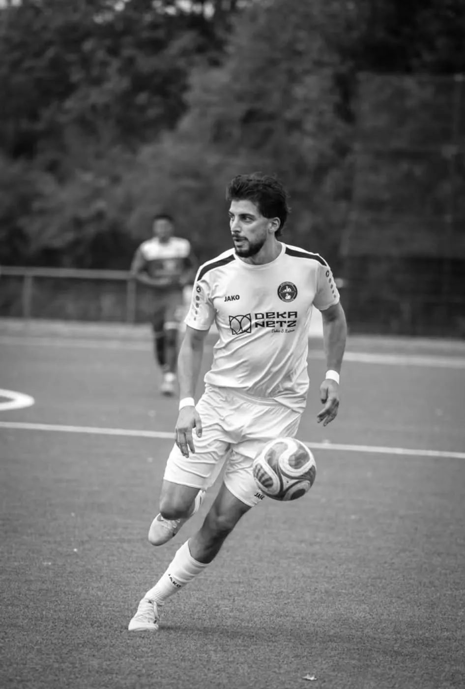 Spieler der Herrenmannschaft im Lauf mit dem Ball, schwarz-weiß