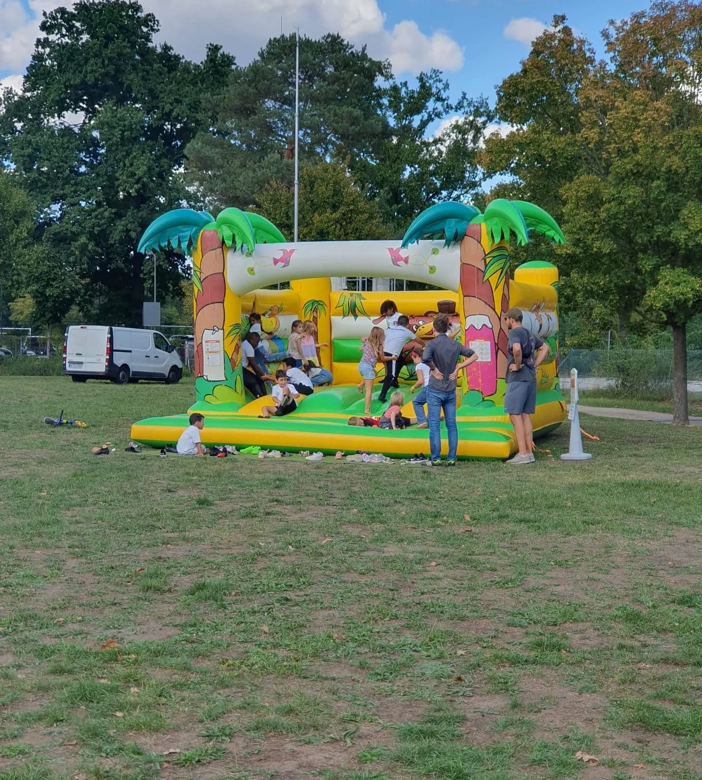 Kinder spielen beim Sommerfest auf einer Hüpfburg