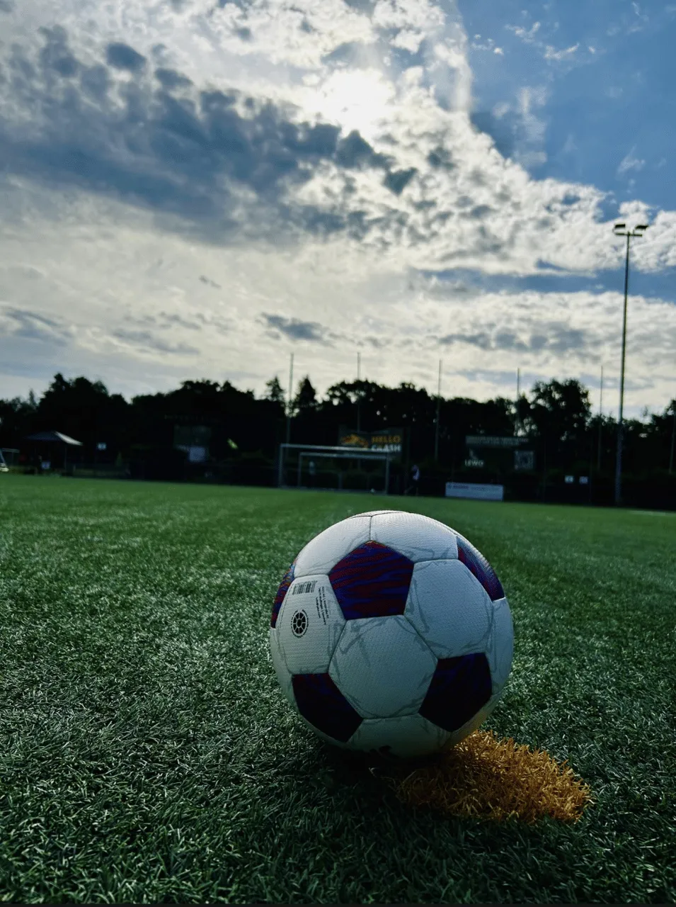 Spielball auf dem Kunstrasen der Sportanlage im Abendlicht